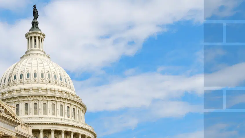 The top of the United States Capitol set against a blue sky with wispy clouds.